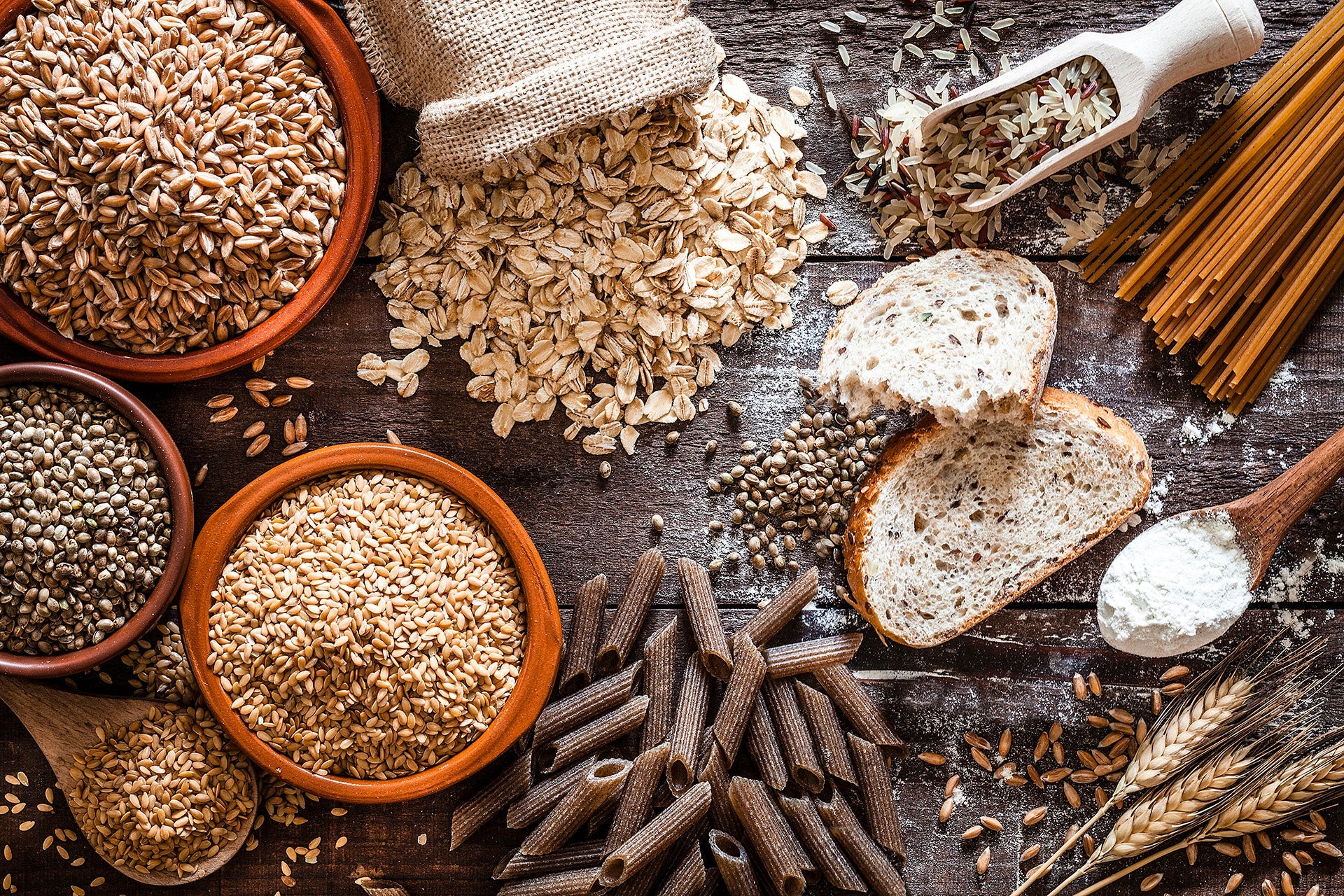 Assorted grains, seeds, and bread on a wooden surface